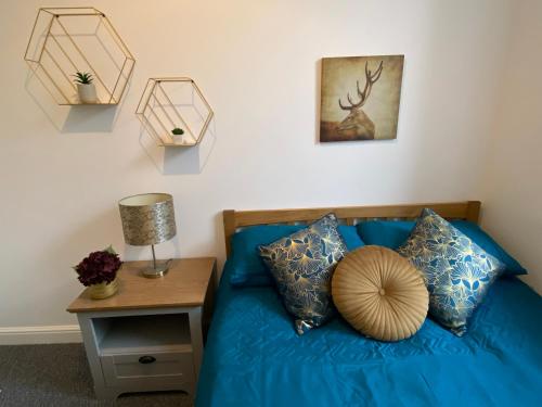 奧本的住宿－Newly refurbished town centre apartment，卧室配有蓝色的床,墙上挂着鹿