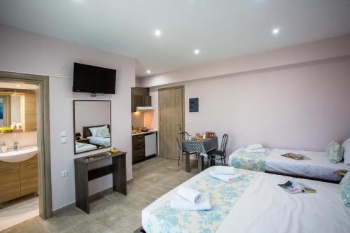 Habitación de hotel con 2 camas y lavamanos en Studio Elena, en Nea Peramos