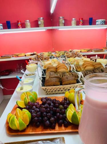 a buffet of food with fruit and pastries on a table at Apart-Hotel Pacífico in Tramandaí