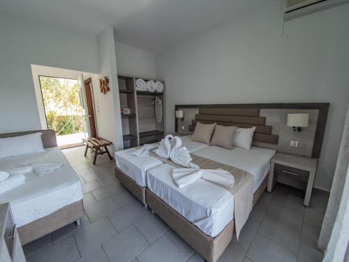 a hotel room with two beds and a sink at Ena-Lia Studios in Skala Marion