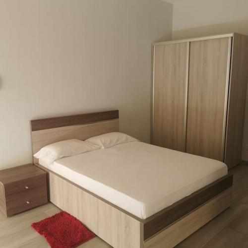 Schlafzimmer mit einem Bett mit einem Kopfteil aus Holz in der Unterkunft Ellen Apartamentos in Espargos