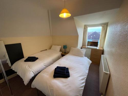 two beds in a small room with a window at 2 Bedroom Holiday Apartment Skegness - Flat 17 in Skegness