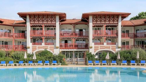 un hôtel avec une piscine devant un immeuble dans l'établissement Location Biscarrosse Lac, à Biscarrosse