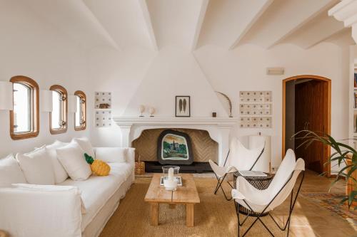 een woonkamer met een witte bank en een open haard bij Hotel Casa Nereta in Cadaqués