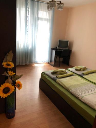 a bedroom with a bed and a vase with sunflowers at Central House in Blagoevgrad