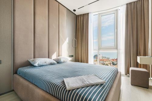 a bedroom with a bed with a large window at Luxury Waterfront 3-bedrooms Apartment in Odesa
