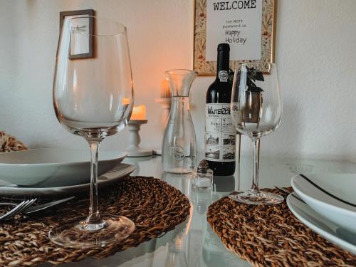 two wine glasses sitting on a table with plates at Berggeflüster Winterberg- im Herzen Winterbergs in Winterberg