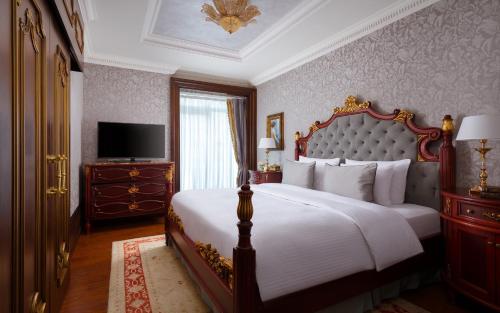 a bedroom with a large bed and a large mirror at Rixos Almaty Hotel in Almaty