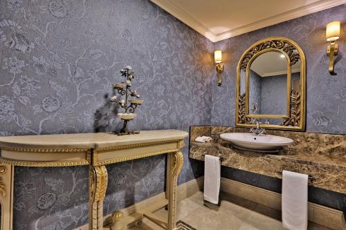 a bathroom with a sink and a mirror at Rixos Almaty Hotel in Almaty