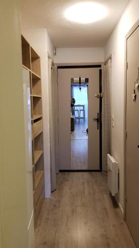 un couloir vide avec une porte menant à une chambre dans l'établissement Les Genets, à Valdeblore