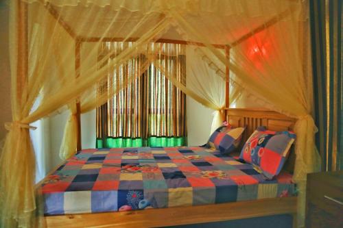 a bedroom with a bed with a canopy at City Elephant Family Resort in Udawalawe