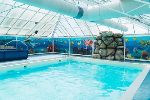 una gran piscina con un parque acuático con un mural de pescado en Kajuit423 6pers 5sterren vakantiepark Bergumermeer aan het water in Friesland met zwembad, en Suameer