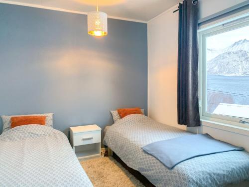 Fjordgård的住宿－Segla Guesthouse - Lovely sea view，一间卧室设有两张床和窗户。