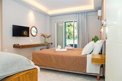 a bedroom with a bed and a tv on the wall at Spyridoula Resort in Corfu in Gouvia