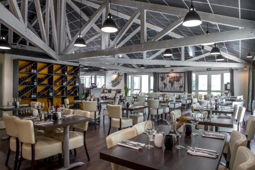 a restaurant with tables and chairs and wine racks at Logis Le Relais de Sassenage in Sassenage