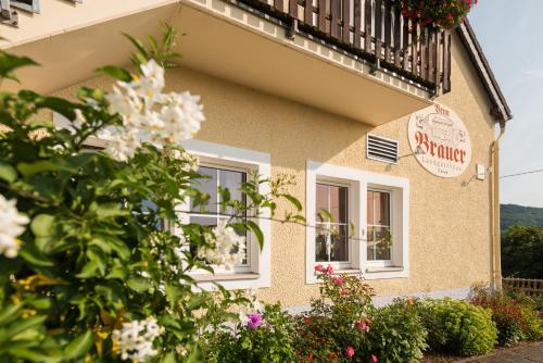 a building with a balcony and flowers in front of it at Brauers Landarthotel GmbH in Daun