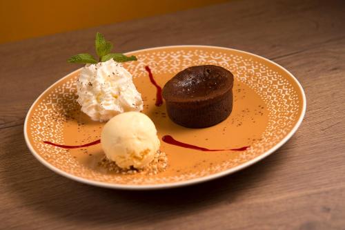 a plate of food with a chocolate cupcake and ice cream at Logis Le Relais de Sassenage in Sassenage