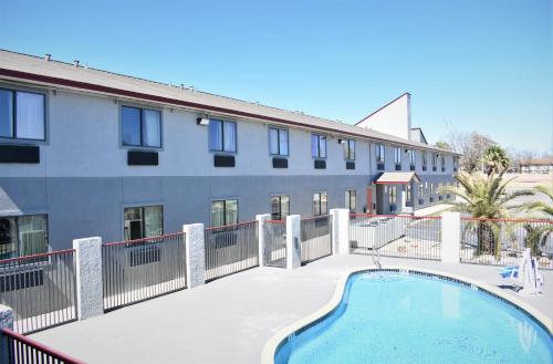a building with a swimming pool in front of a building at Super 8 by Wyndham New Braunfels I-35 in New Braunfels