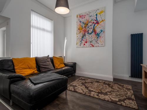 uma sala de estar com um sofá e uma pintura na parede em Apex Living NE - Beachville House II 4 Beds FREE PARKING em Sunderland