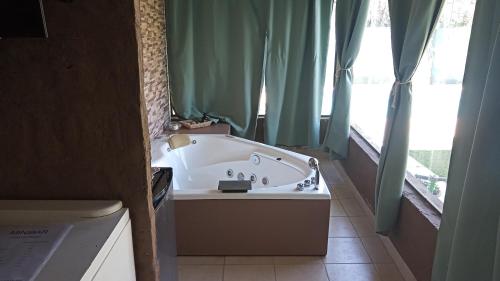 a bath tub in a bathroom with green curtains at Departamento Para Relax y Descanso in Ciudad Lujan de Cuyo