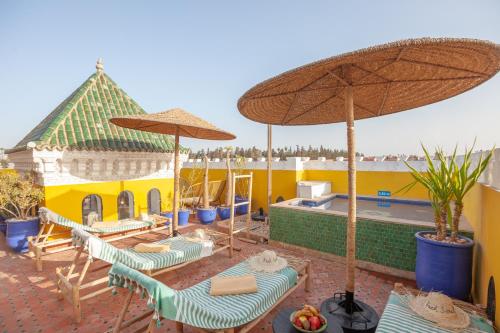 a patio with chairs and umbrellas and a pool at Riad Kech Soul Boutique & Spa in Marrakesh