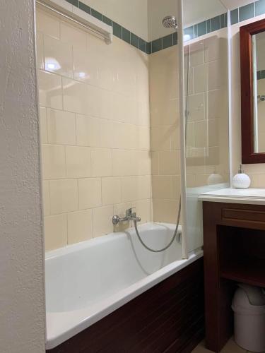 une salle de bain avec une baignoire et un lavabo dans l'établissement Appartement a loué domaine de gasgogne a biscarrosse, à Biscarrosse