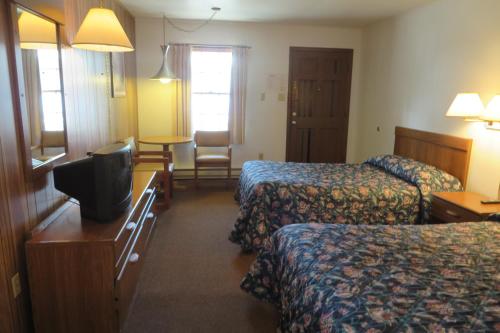 a hotel room with two beds and a television at Seacrest Motel in Sandusky