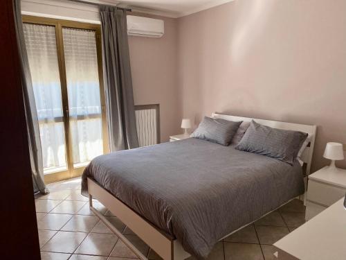 a bedroom with a bed and a large window at La Casa di Placido in Pescara