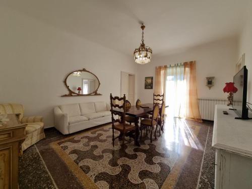 sala de estar con mesa y sofá en WOW HOME 2 - 175 mq - posteggio privato - davanti porto traghetti - fino a 10 posti letto - balcone, en Génova