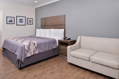 een hotelkamer met een bed en een bank bij Americas Inn & Suites IAH North in Humble