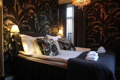 a bedroom with a bed with black and gold wallpaper at Karstorp Säteri – Hotell och Konferens in Skövde