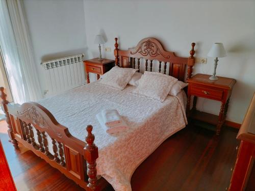 a bedroom with a large wooden bed with two night stands at Casa das Mareas in Muros
