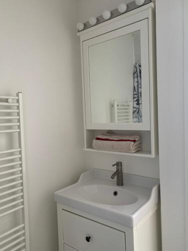 une salle de bain blanche avec un lavabo et un miroir dans l'établissement Beau T2 clim terrasse idéalement situé, à Aix-en-Provence