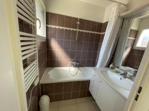 La salle de bains est pourvue d'une baignoire et d'un lavabo. dans l'établissement SAPHIR - Vue Mer et Montagne - WIFI FIBRE- PISCINE et GARAGE Privé, à Collioure