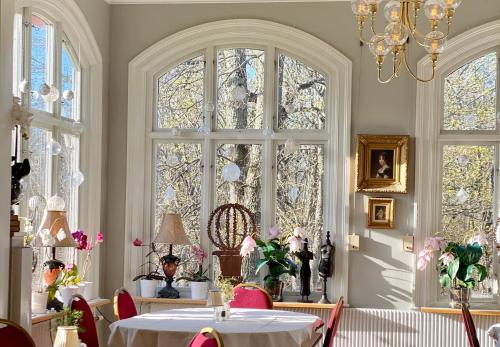 a dining room with a table and some windows at Karstorp Säteri – Hotell och Konferens in Skövde