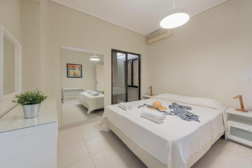 um quarto branco com uma cama e um espelho em Phoenix Apartments em Zakynthos Town
