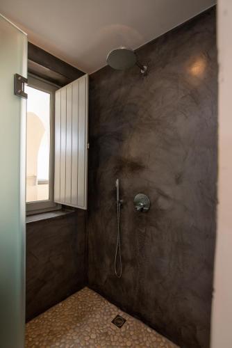 a bathroom with a shower with a window at Caldera Cliff Illusion in Fira