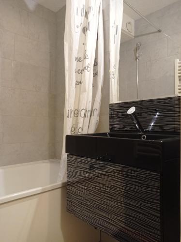 une salle de bains avec lavabo et baignoire dans l'établissement Puy Saint Vincent 1700, à Puy-Saint-Vincent