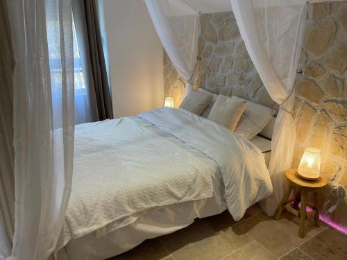 1 dormitorio con cama blanca y pared de piedra en Romantica Spa en Saint Die