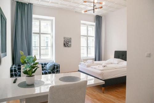 ein Wohnzimmer mit einem Tisch und einem Bett in einem Zimmer in der Unterkunft Big Apt in Viennas Center - Perfect for Longstays in Wien
