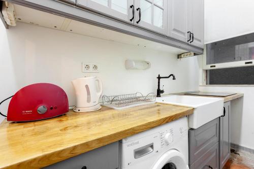 una cocina con lavadora y un aparato rojo en Origine Rentals Galata L1, en Estambul