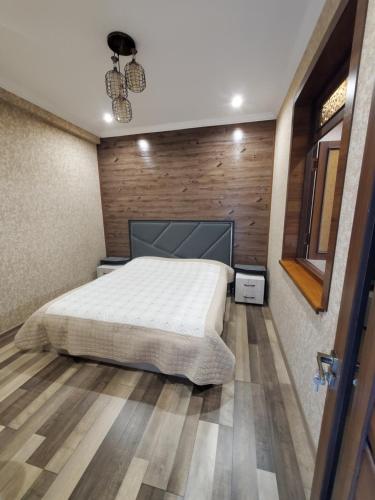 een slaapkamer met een bed en een houten wand bij Apartment Vokzal 2 in Samarkand