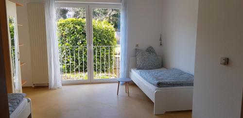 Zimmer mit einem Bett und einer Glasschiebetür in der Unterkunft Ferienwohnung Tim in Zweibrücken