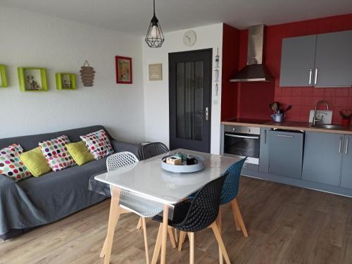 een woonkamer met een bank en een tafel en stoelen bij L Îlot de la Baie, super studio 4p face à la mer, parking gratuit, wifi, classé 2 étoiles à Fort Mahon Plage, Baie de Somme in Fort-Mahon-Plage