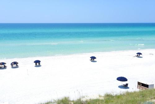 a group of umbrellas on a beach with the ocean at Beach Bungalow, 3 Min Walk to Beach, Golf Cart, 4 bikes, Wagon in Seacrest