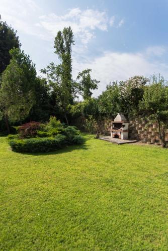 a grassy yard with a stone wall and a structure at Psi·Theros in Kriopigi