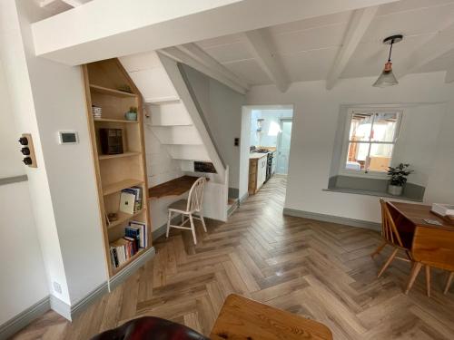a living room with a staircase and a table at Peaceful period cottage in central location in Penzance