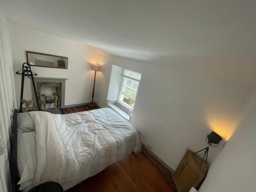a small bedroom with a bed and a window at Peaceful period cottage in central location in Penzance