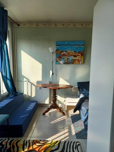 un salon avec une table et un canapé dans l'établissement Bleu d'Arques Appartement lumineux et calme, à Dieppe