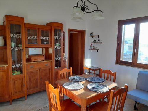een eetkamer met een houten tafel en stoelen bij Casa di Jacu in Favignana